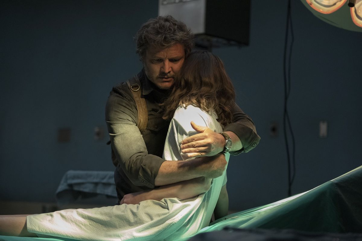 Joel levanta a Ellie sobre su hombro desde la mesa de operaciones de un hospital en una escena de The Last of Us de HBO.