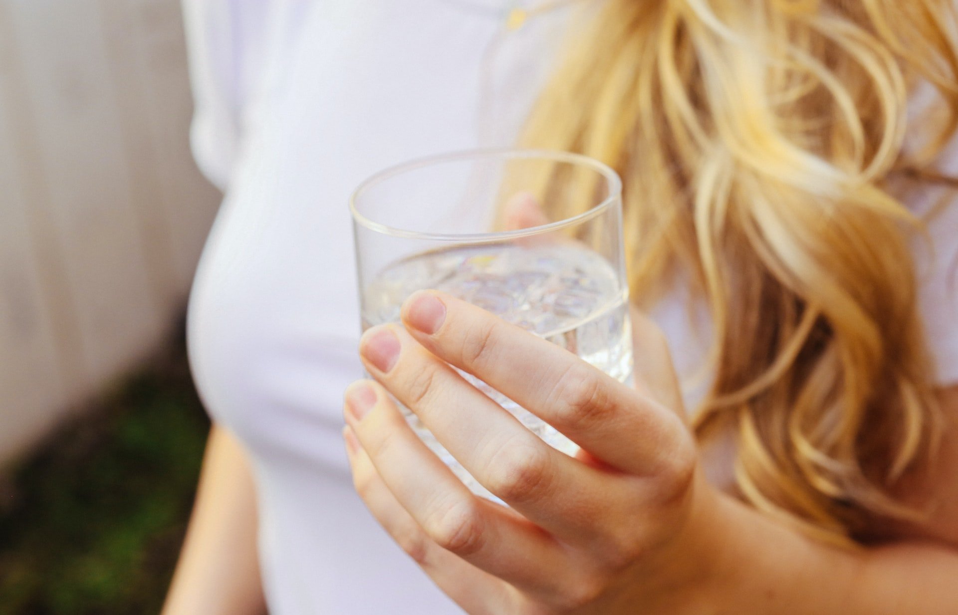 A woman holding a glass of water.