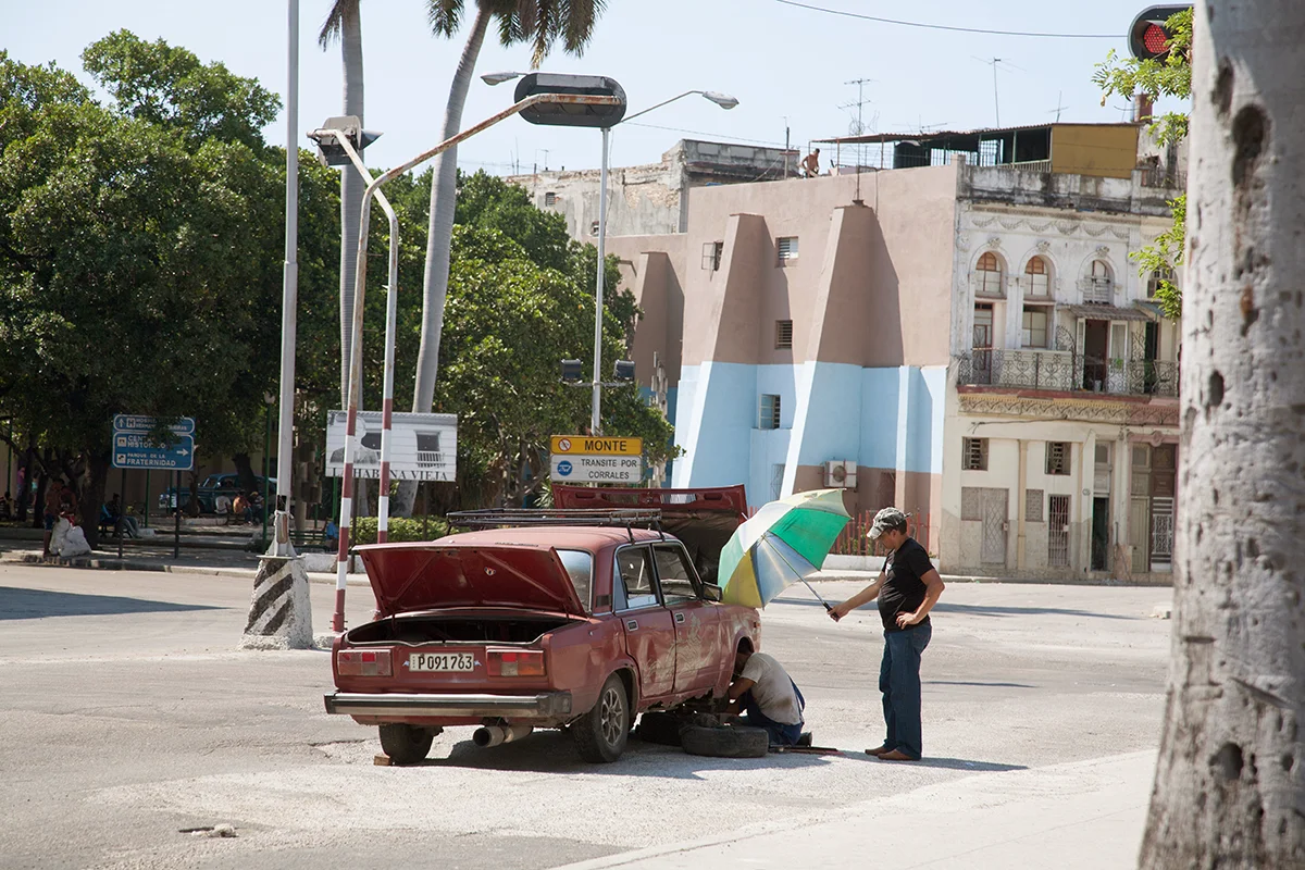 Ein Mechaniker wird während der Arbeit an einem kaputten Auto in Havanna, Kuba, beschattet.