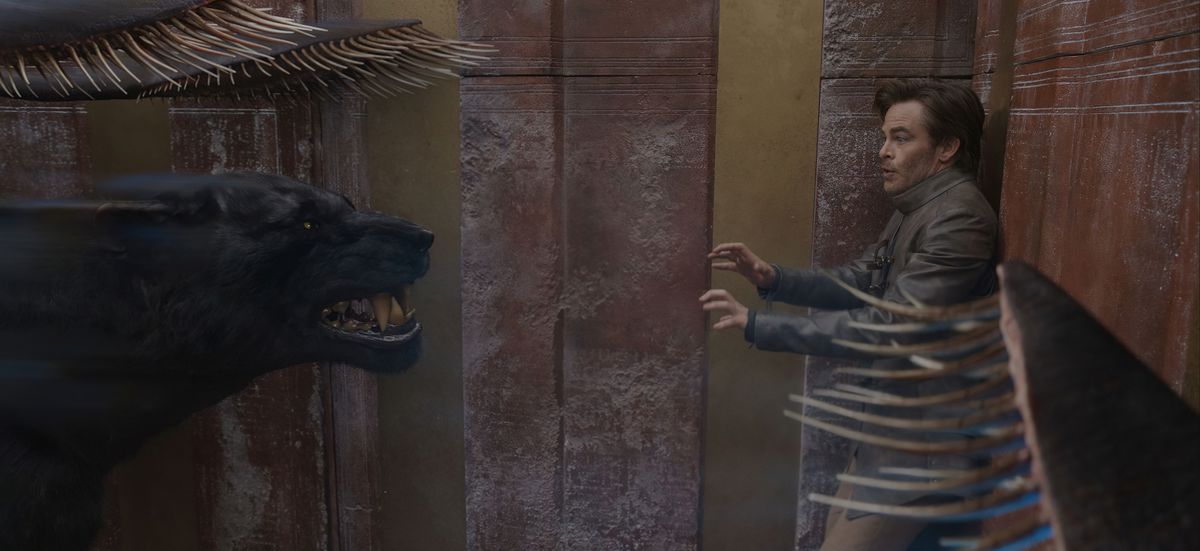Edgin the Bard (Chris Pine) gaat in paniek achteruit tegen een muur terwijl een verdringerbeest hem in het nauw drijft in Dungeons & Dragons: Honor Among Thieves