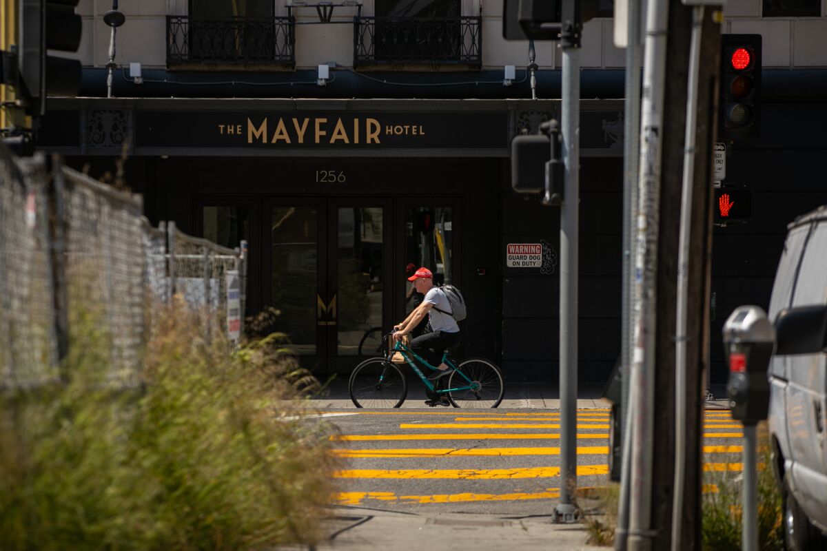 Un ciclista pasa frente al Mayfair Hotel, un hotel de 15 pisos en el vecindario Westlake de Los Ángeles.
