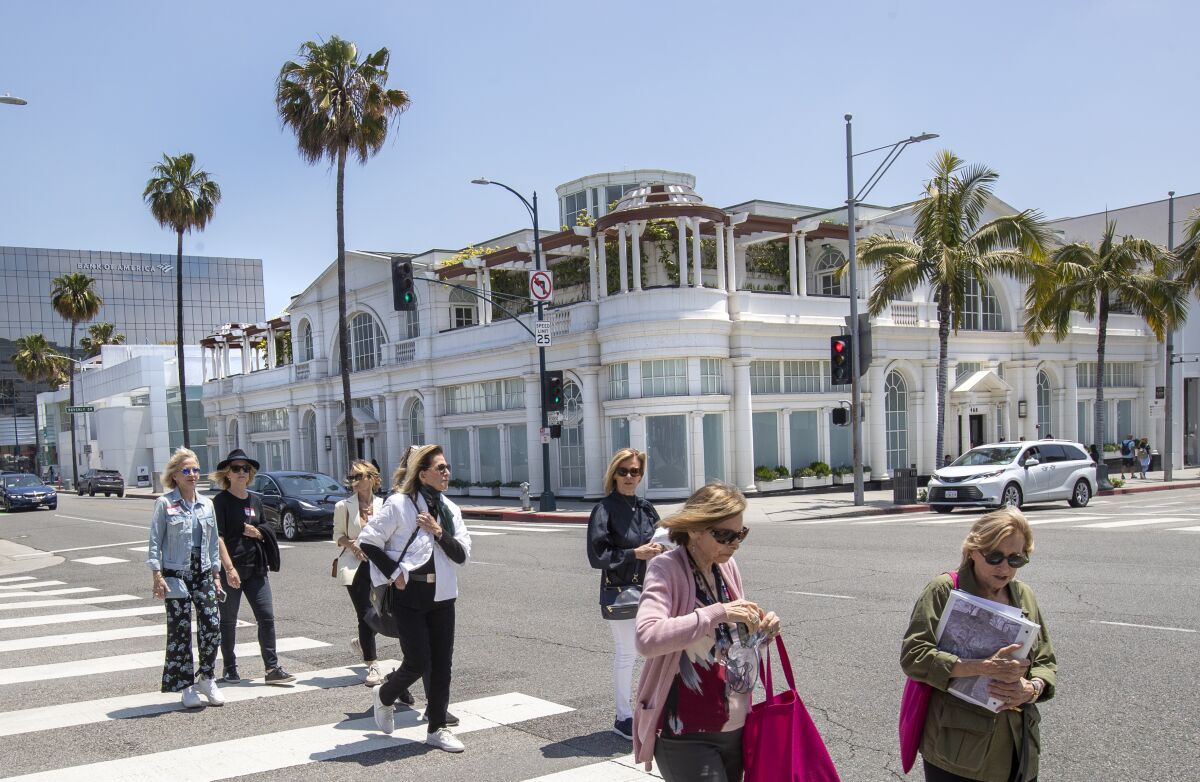 Fußgänger gehen an einem Gebäude an der Kreuzung Rodeo Drive und Santa Monica Blvd vorbei.