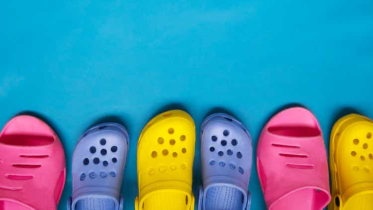Zapatillas de colores brillantes para mujeres y niños, chanclas sobre un fondo azul. lugar para texto