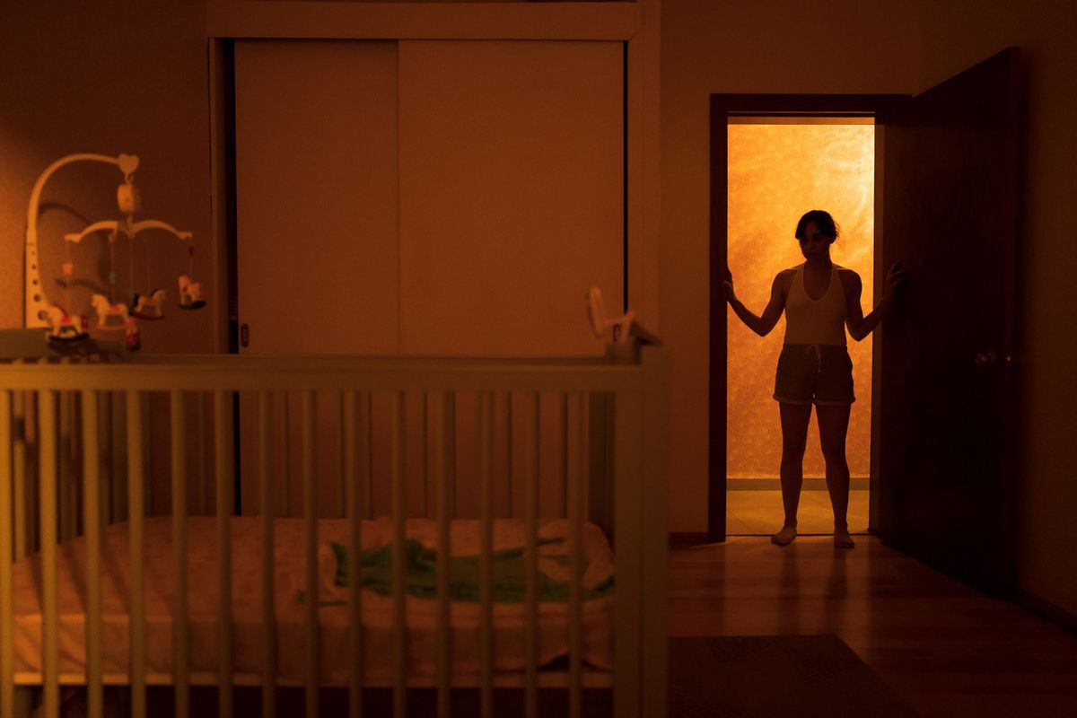 Силуэт женщины стоит в дверях освещенной сзади детской в ​​фильме ужасов Huesera: The Bone Woman.