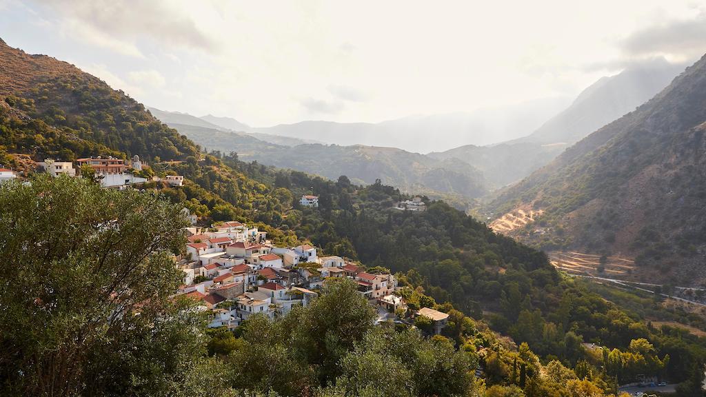 Weergave van een dorp omgeven door bos op Kreta, Griekenland, van bovenaf.