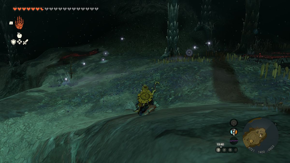 Link, Zelda Tears of the Kingdom'da Derinliklerde ateşböceklerini ararken çömelir.