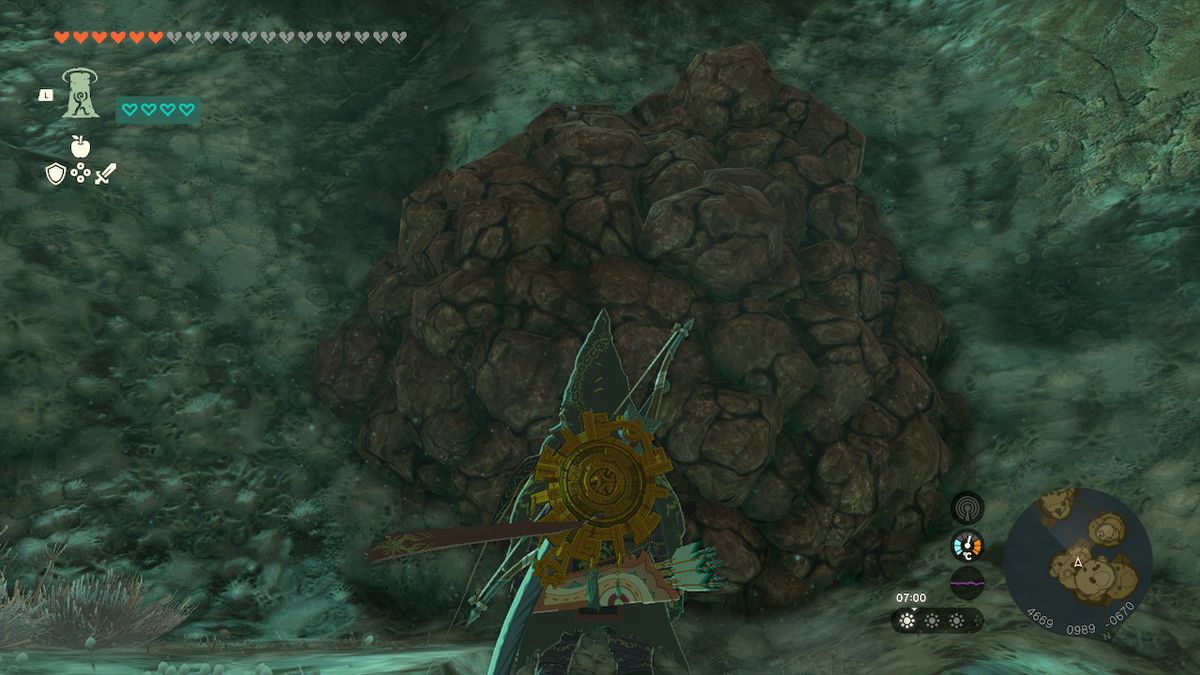 Link stands by a pile of rubble in the Depths while looking for the Wind Armor in Zelda Tears of the Kingdom.