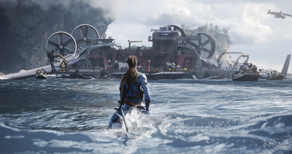 A Na’vi warrior sitting at water level on the ocean, riding a submerged sea creature, is seen from behind, looking at an immense mechanical human ship covered with rotors and engines in a shot from Avatar: The Way of Water