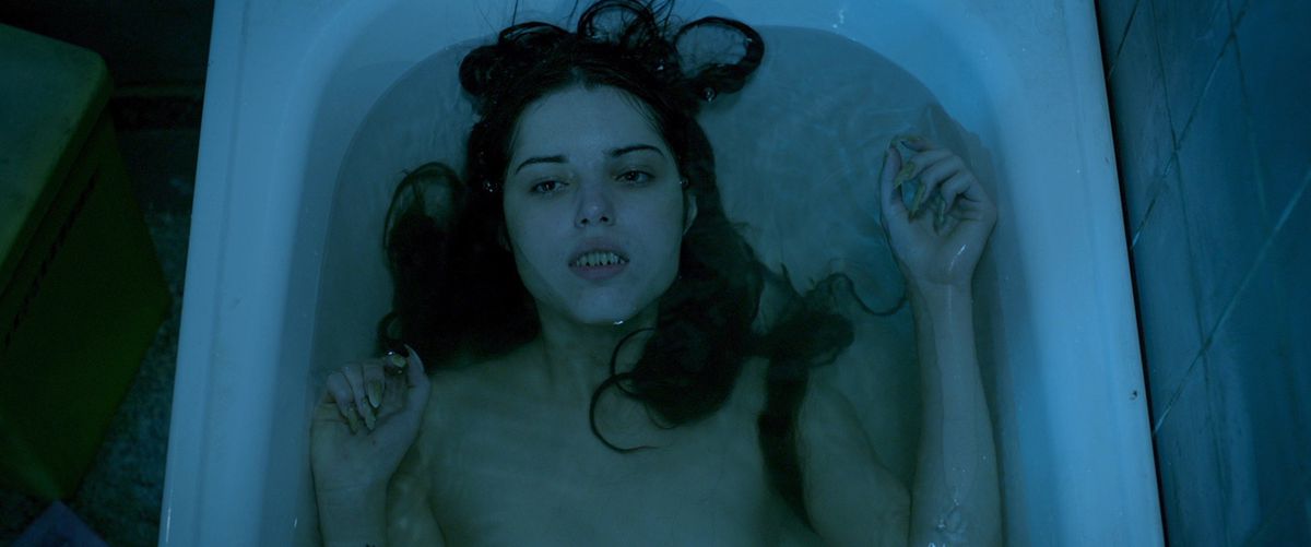 een prachtige zeemeermin met vlijmscherpe tanden ligt achterover in een badkuip