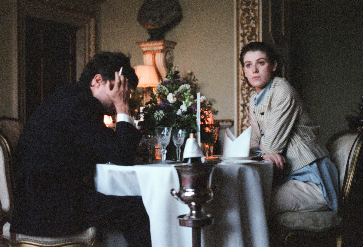 Julie, de Honor Swinton Byrne, se sienta frente a su desaliñado novio Anthony durante un té en un elegante restaurante en The Souvenir.