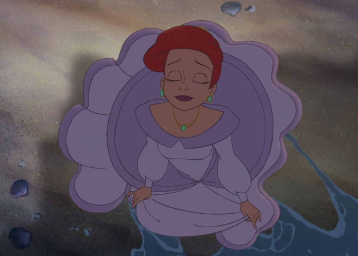 Yetişkin bir Ariel gözlerini kapatır ve bir ayağını deniz suyuna sokar.
