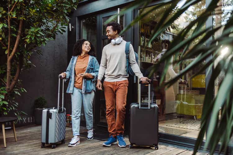 Touristes afro-américains avec des valises devant l'appartement loué