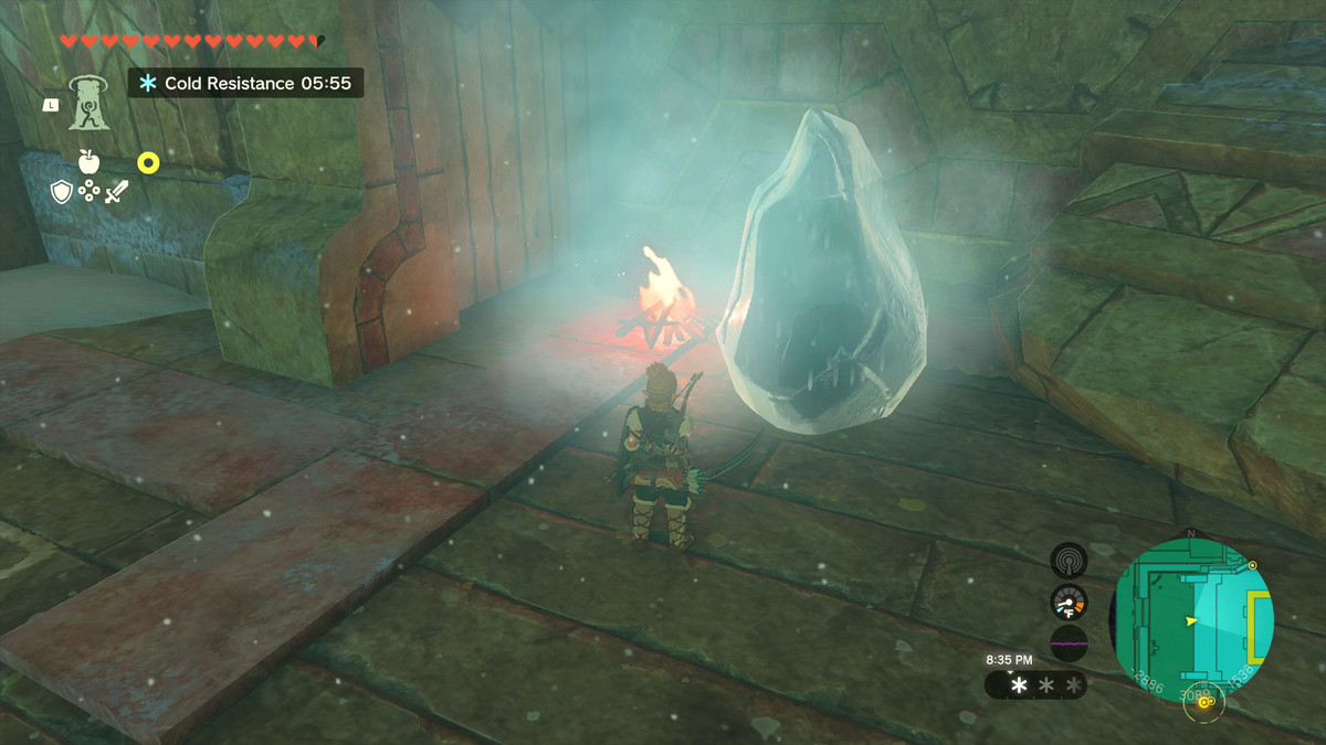 Link, bir soğukluk havası yayan buzlu bir kayanın önünde duruyor. Solda buzları eriten küçük bir kamp ateşi var.