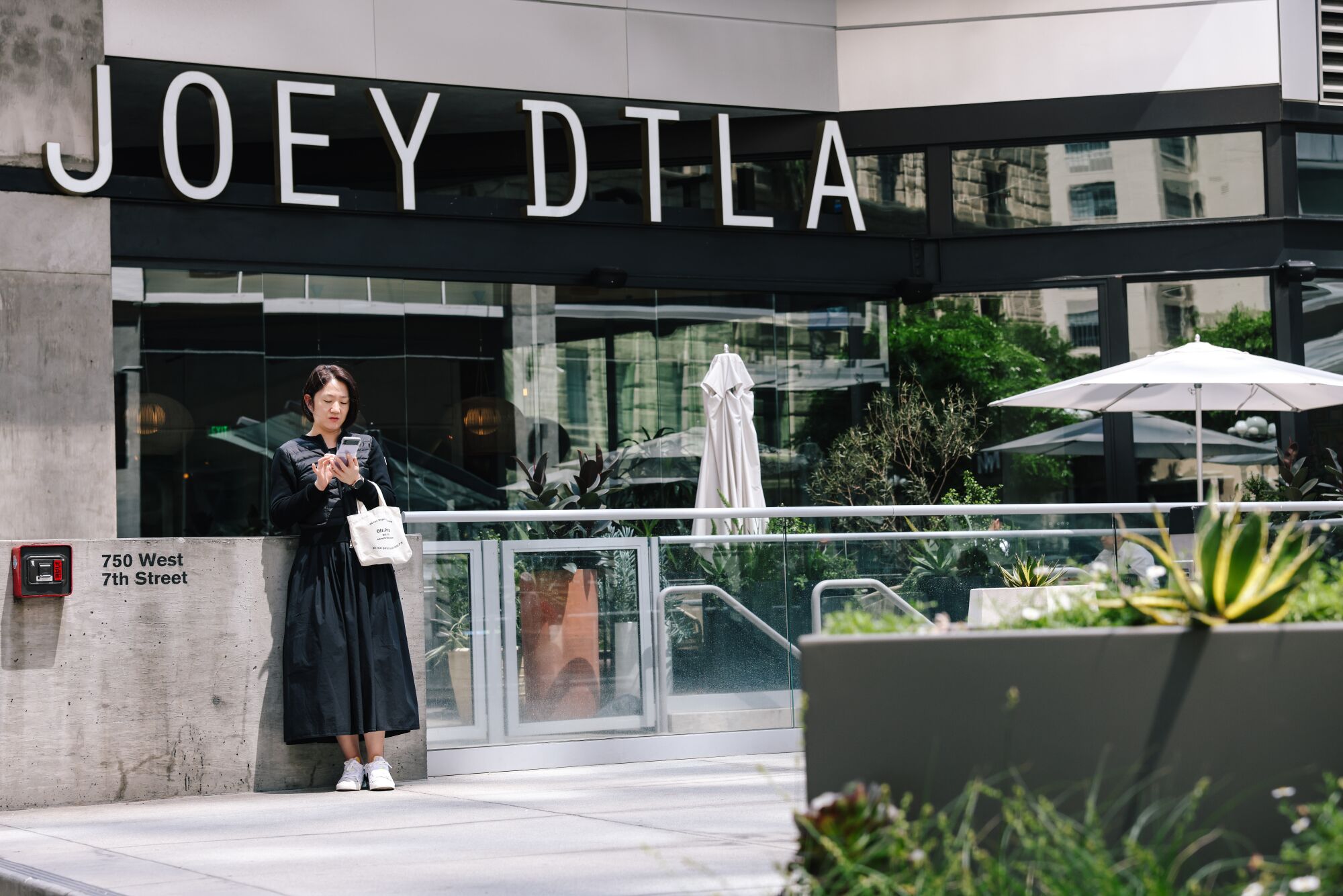 Una mujer frente al restaurante Joey DTLA en el distrito financiero del centro.