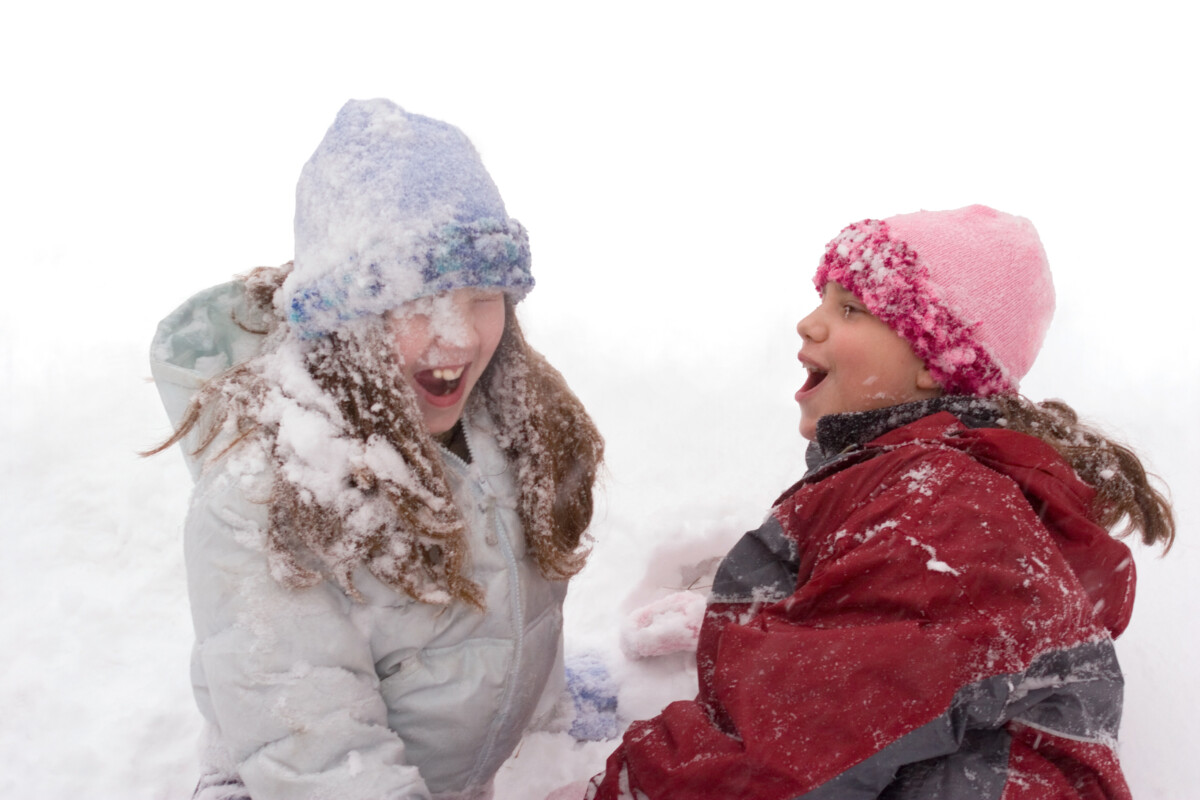 Twee jonge meisjes spelen in de sneeuw