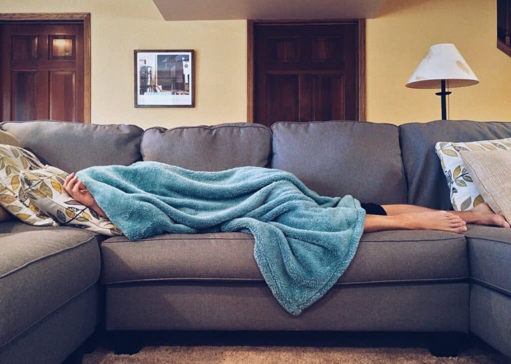 individual sleeping on the couch from a hangover