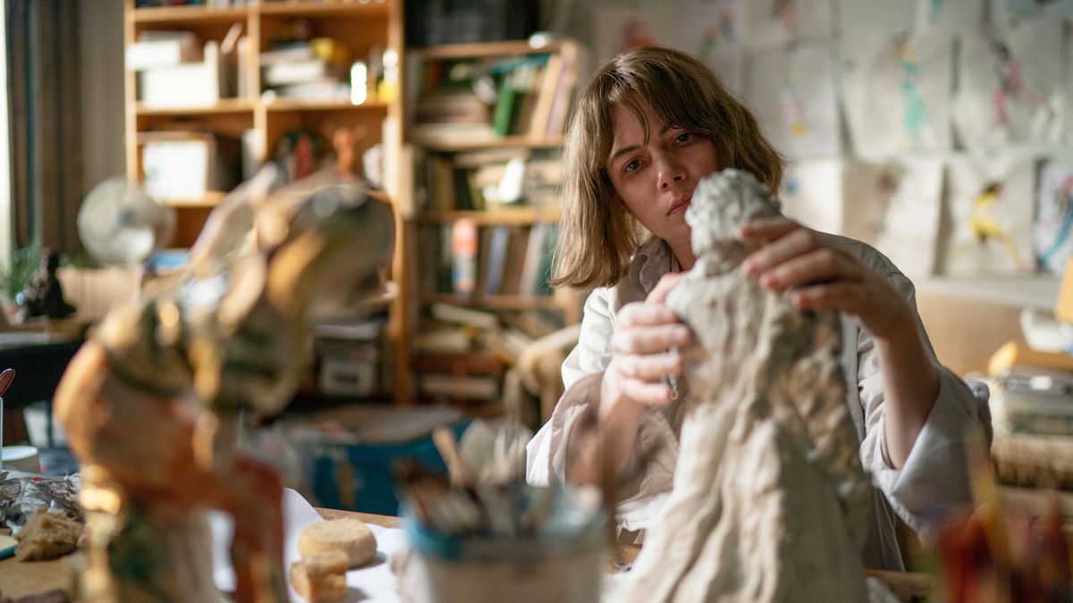 Michelle Williams moldeando una escultura en un estudio de arte en Showing Up.