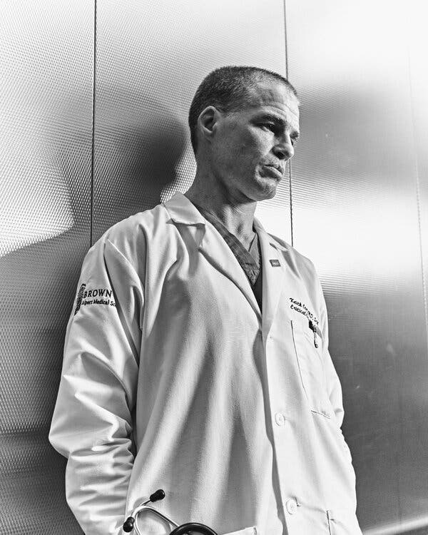 Una fotografía en blanco y negro de Corl con una bata médica blanca, mirando hacia abajo.