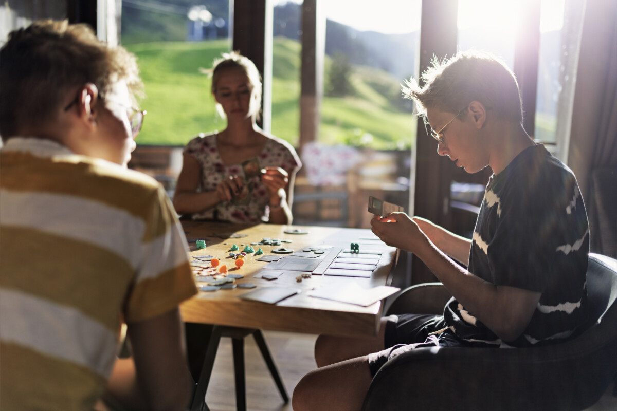 Family playing large modern board game together at home