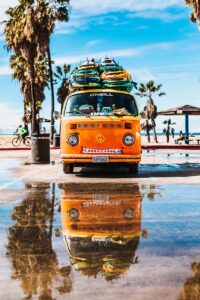 Üstünde sörf tahtası olan turuncu minibüs