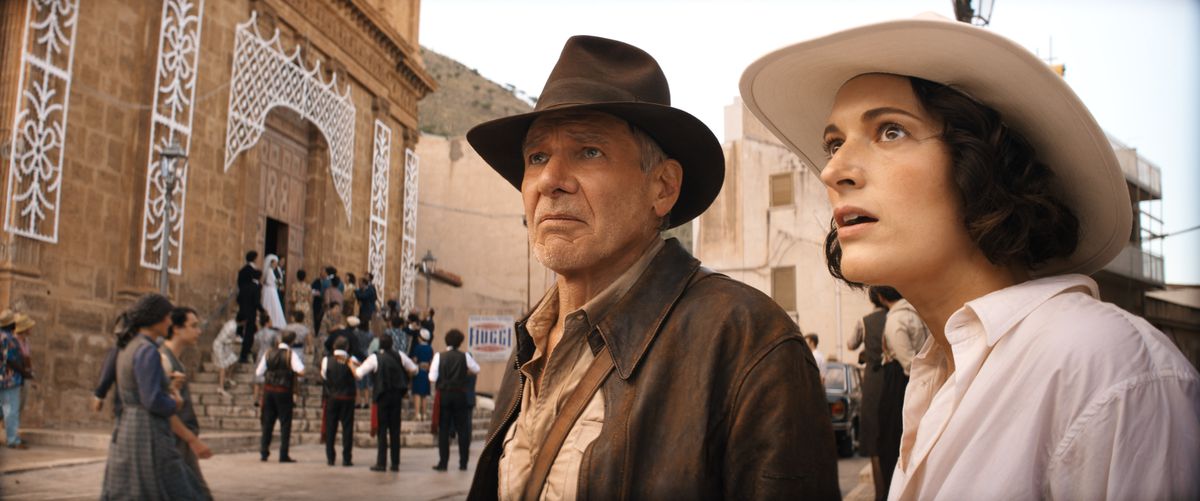 Một cảnh quay từ Indiana Jones và Vòng quay định mệnh; Indy (bên trái) và đối thủ/đối tác mới Helena Shaw (bên phải), cả hai đều đội mũ phớt, nhìn thấy thứ gì đó trên đường phố Tangier.