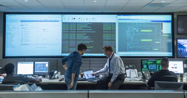 Colleagues working together in server control room for data security and data governance