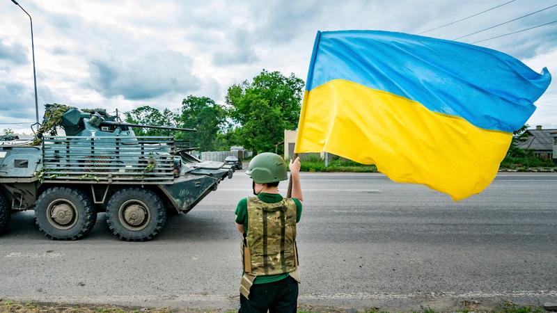 Ein Junge schwenkt eine ukrainische Flagge, als ein gepanzertes Fahrzeug der ukrainischen Armee an die Bachmut-Front fährt, in Slowjansk, Ukraine, 27. Juni 2023, Foto von Celestino Arce/NurPhoto/Reuters