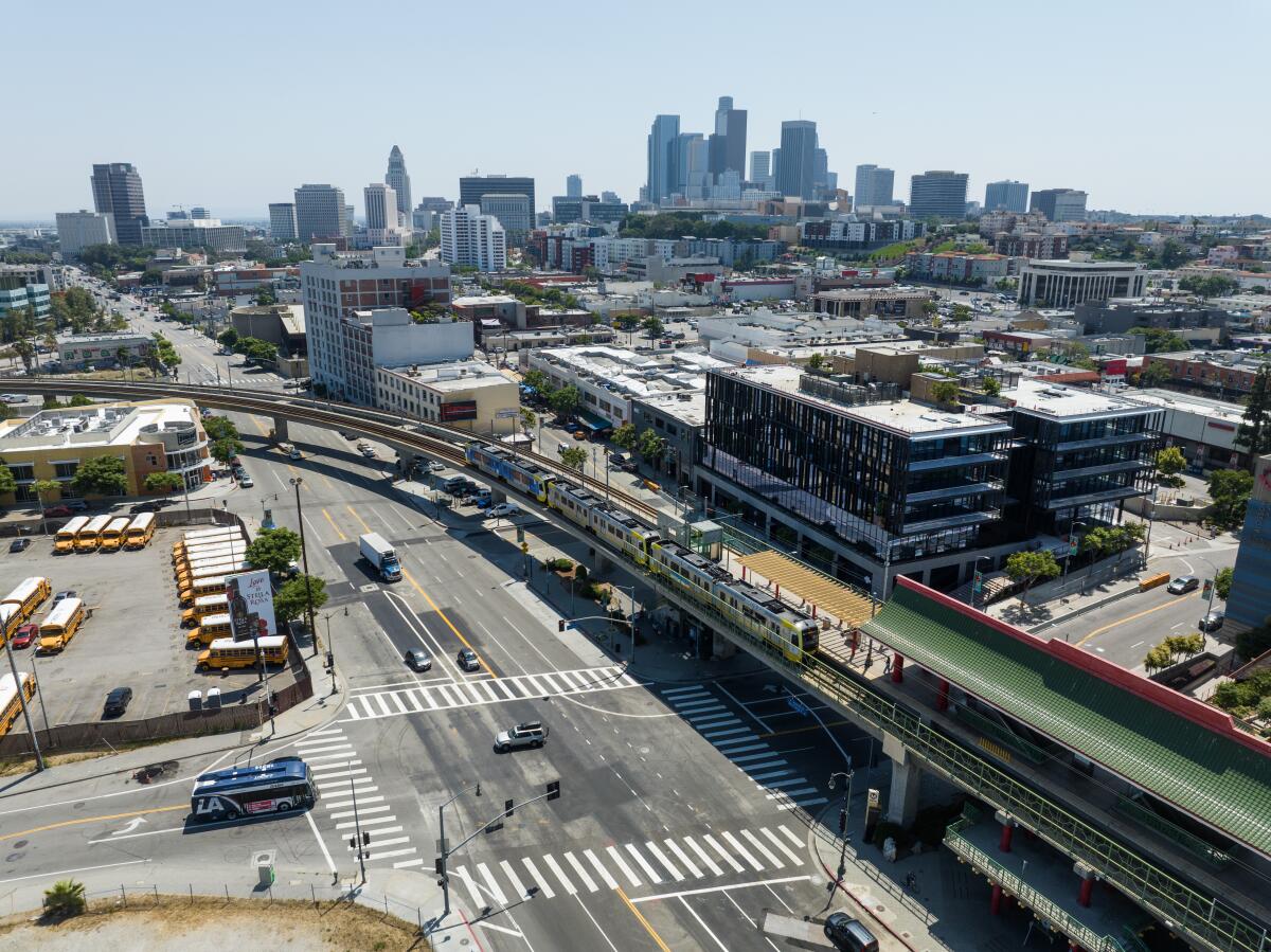 Die Innenstadt von Los Angeles ist hinter einer erhöhten U-Bahn-Station und einem vierstöckigen Geschäftsgebäude im Vordergrund sichtbar.