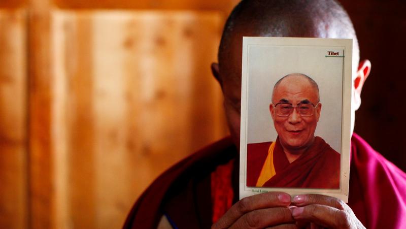 A monk in Gansu Province, China, holds a picture of the Dalai Lama ahead of the Tibetan New Year, February 21, 2012, photo by Carlos Barria/Reuters