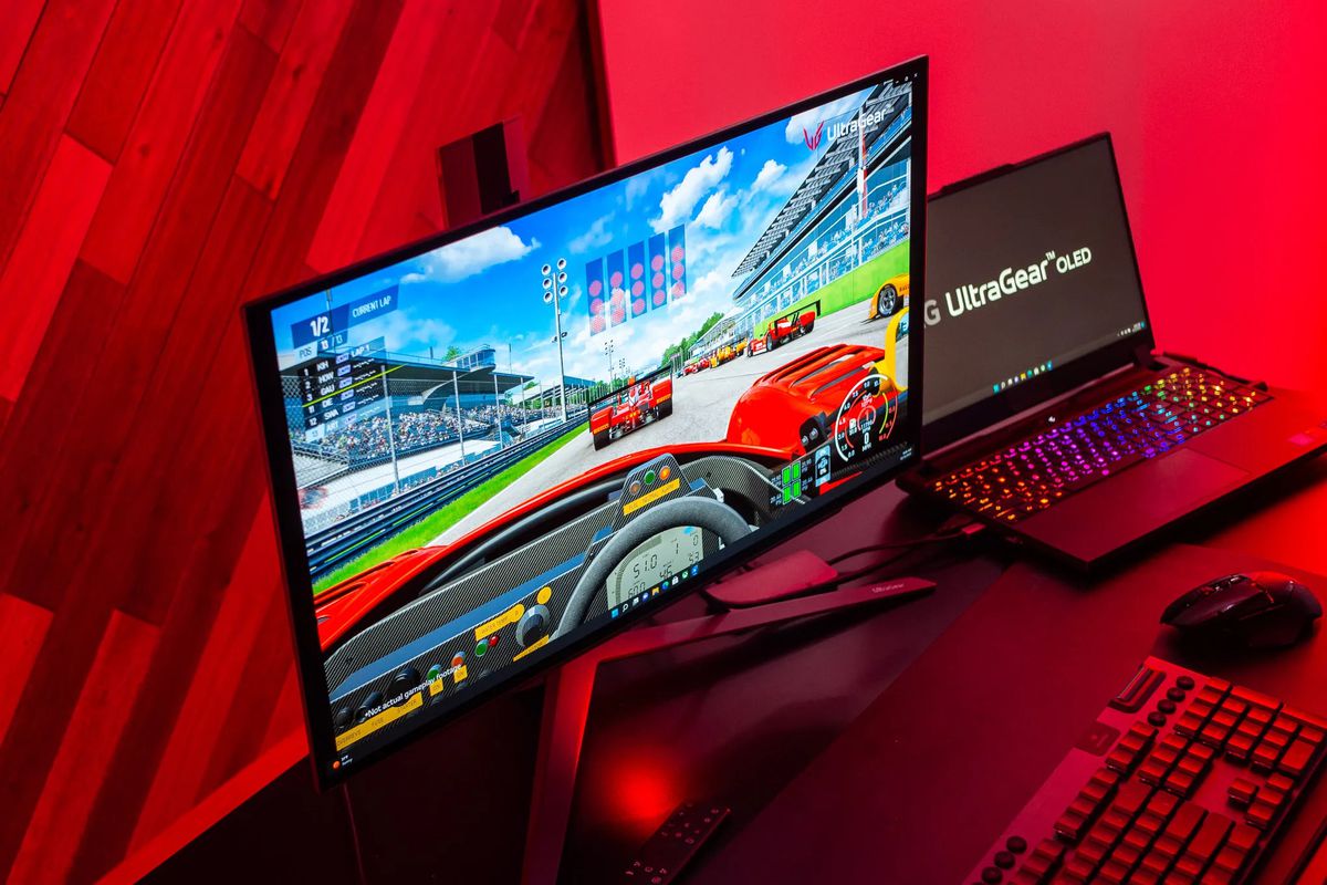 An image of the 27-inch LG UltraGear OLED connected to a PC in an all red room. The monitor is displaying a racing game.