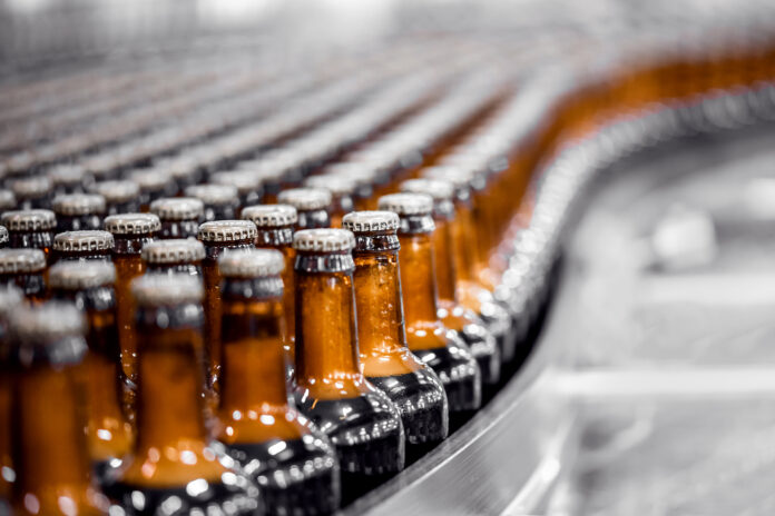 زجاجات البيرة على خط إنتاج الناقل. صناعة الجعة صناعة المواد الغذائية مصنع.