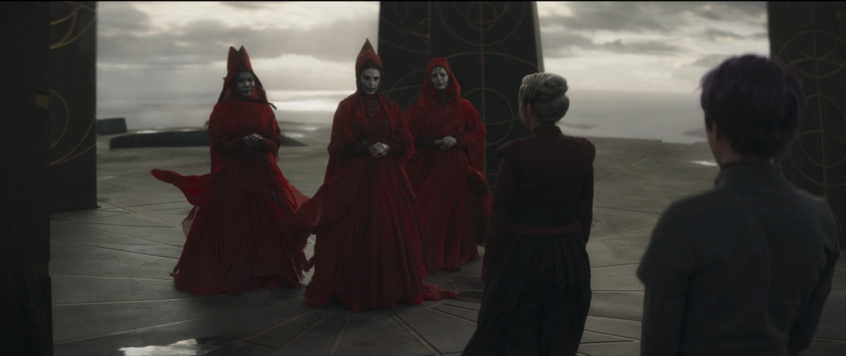 The Witches of Dathomir standing with their hands clasped looking at Elsbeth