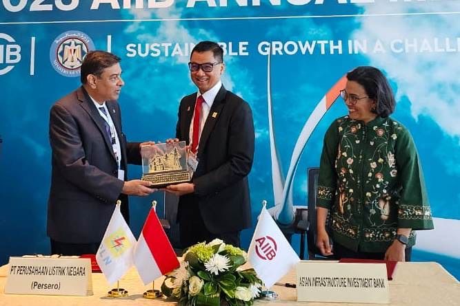 Darmawan Prasodjo, President Director of PLN (middle) hands over a souvenir to Investment Operations Vice President of AIIB Urjit R. Patel, witnessed by Sri Mulyani, Ministry of Finance of Republic of Indonesia.