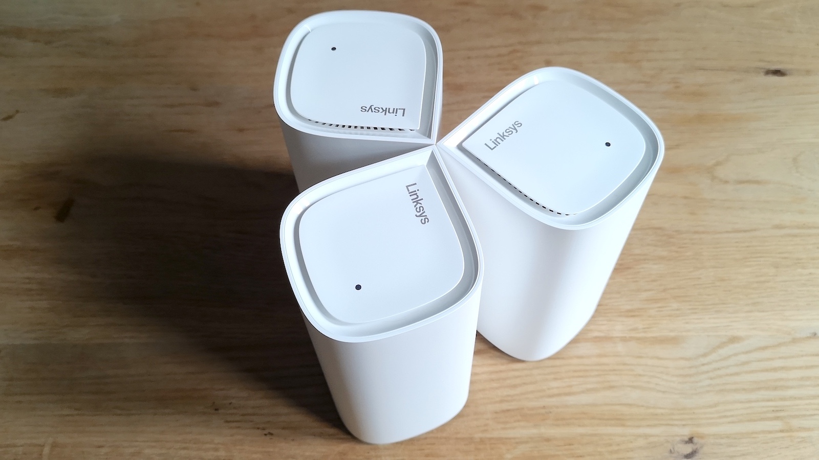 Three Linksys Velop Pro 6E mesh Wi-Fi review units viewed from above, displaying the teardrop shape of the cases