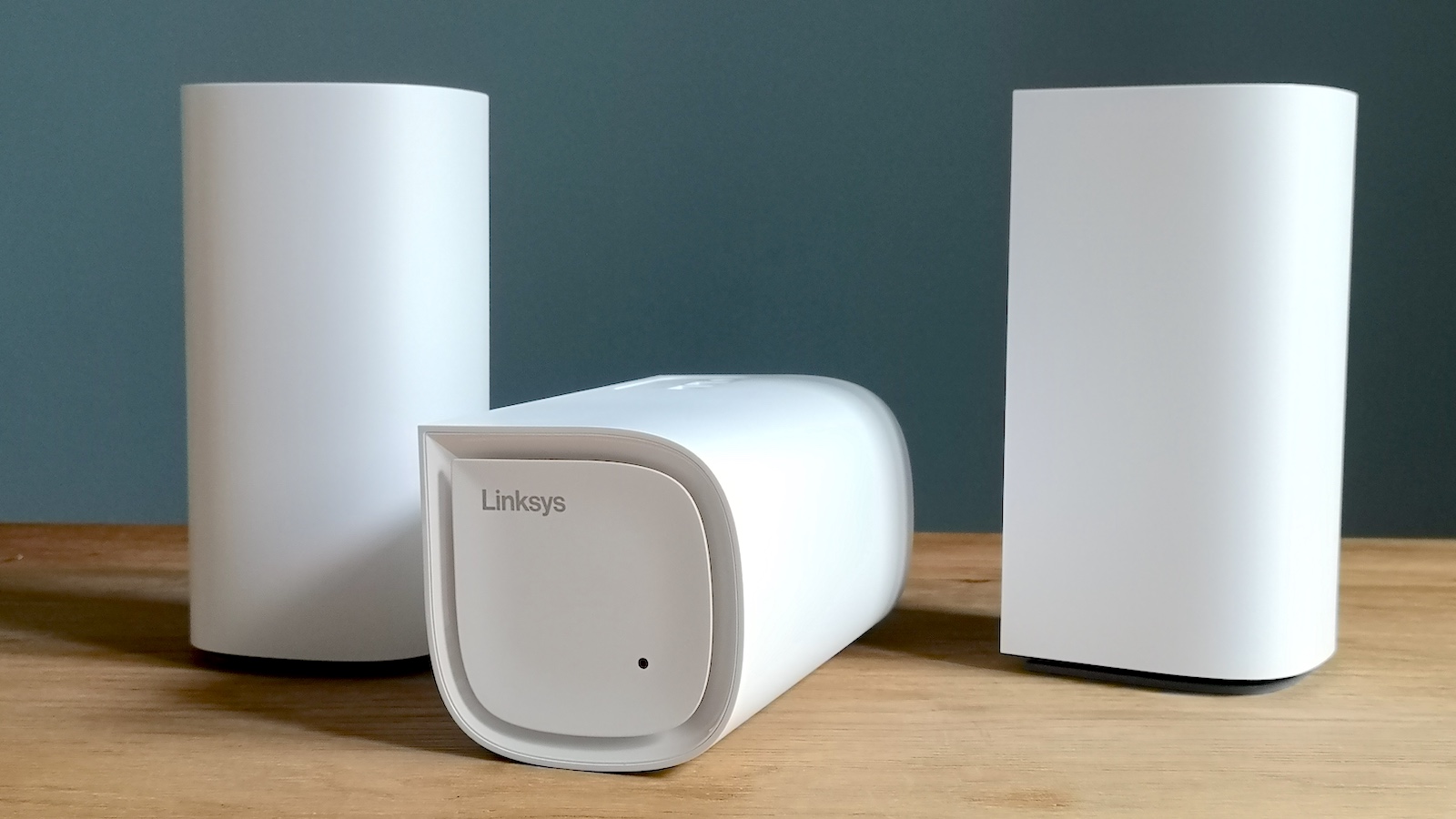 Three Linksys Velop Pro 6E units, one lying on its front, two stood up