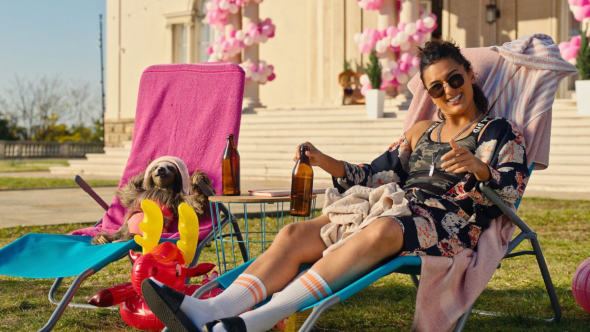 (LR) スロザーハウスの芝生椅子に横たわるナマケモノとマディソン役のオリヴィア・ルイール。