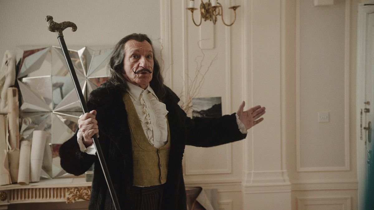 Ben Kingsley como Salvador Dali sosteniendo un bastón en Daliland.