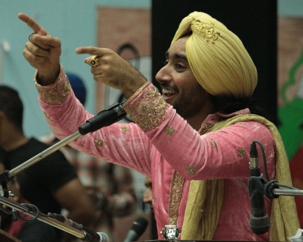 un retrato del artista Satindar Singh Sartaj cantando.