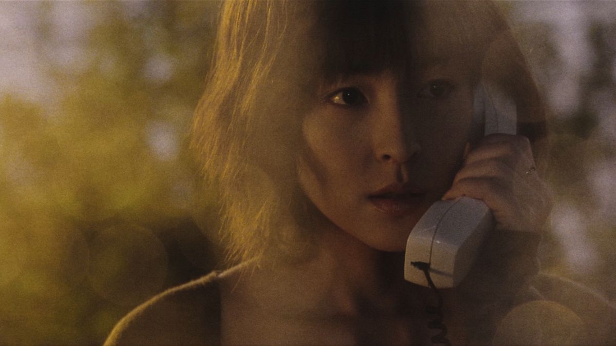 Pulse'ta Michi Kudo rolünde Kumiko Asō kablolu bir telefon ahizesini kulağına tutuyor.