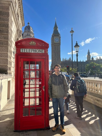 David leunt tegen een rode brievenbus voor de Big Ben in Londen.