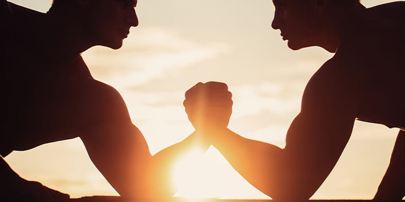 Twee mannen houden elkaars hand vast tijdens een wedstrijd