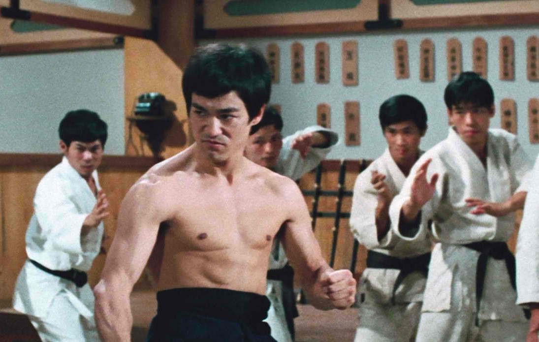 een shirtloze Bruce Lee is klaar voor een gevecht in Fist of Fury