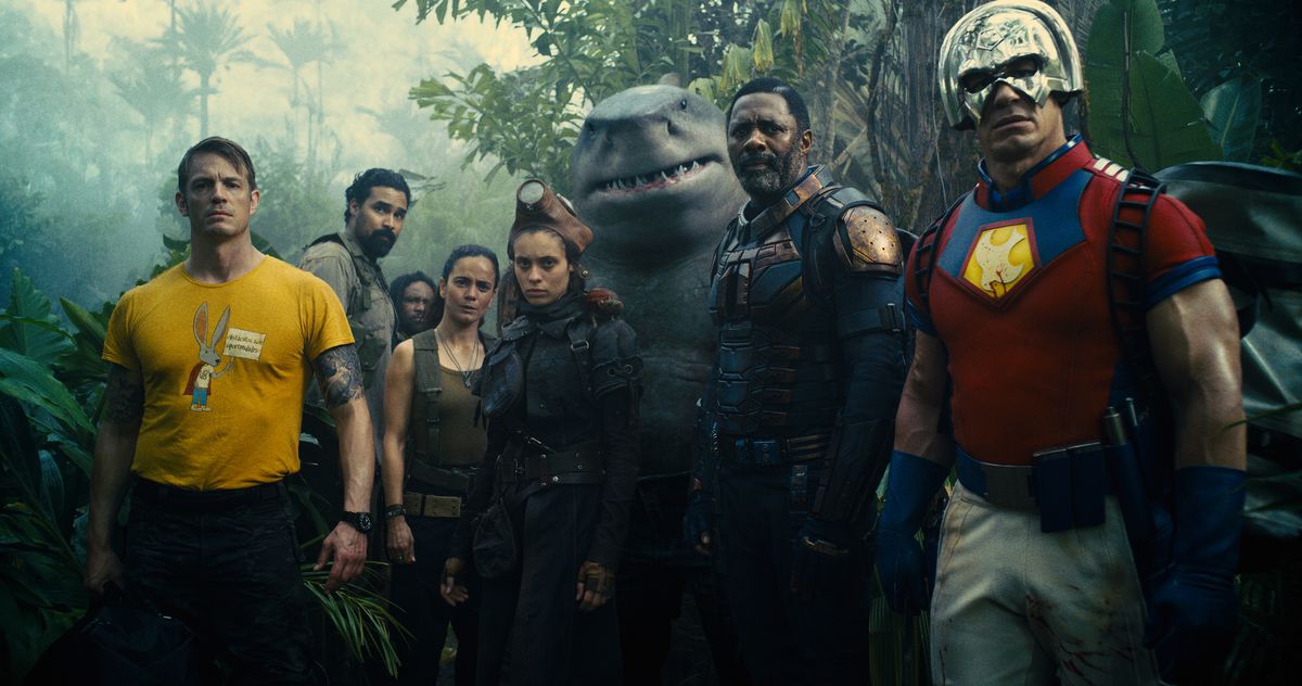 (LR) Joel Kinnaman, Alice Braga, Daniela Melchior, Idris Elba ve John Cena, The Suicide Squad'da tropikal bir orman açıklığında duruyor.