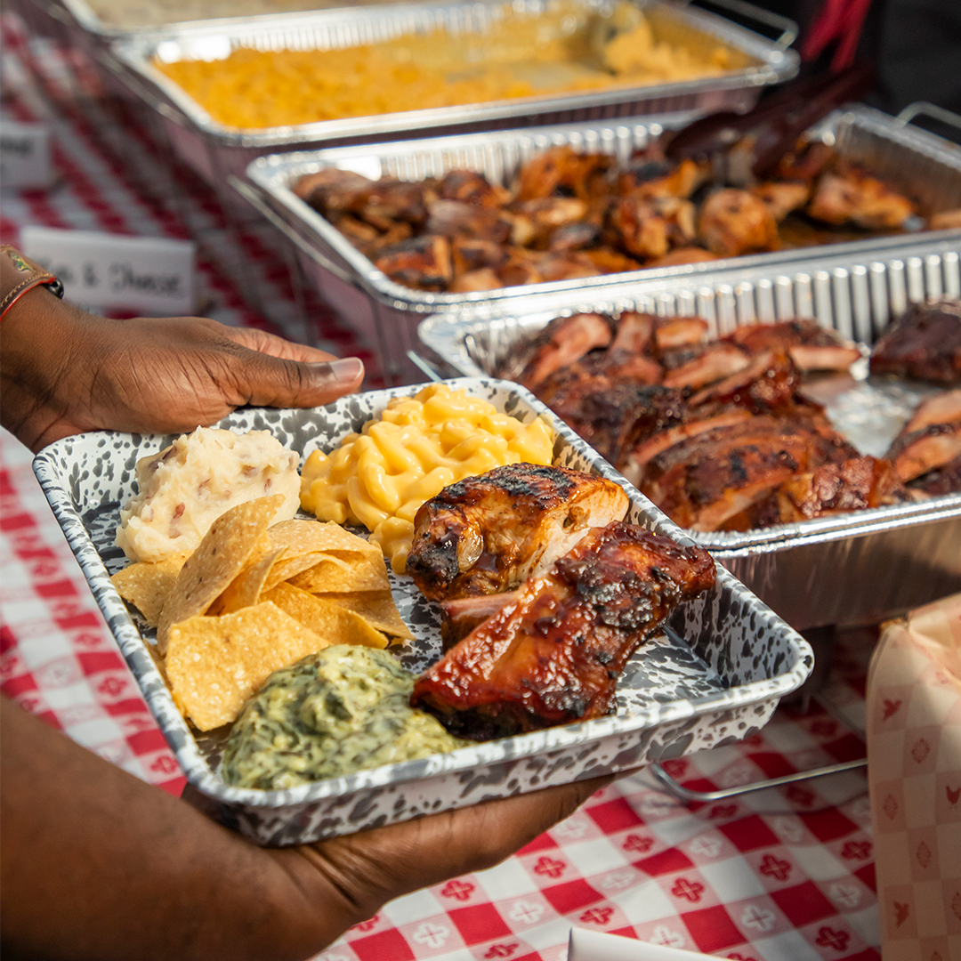 person putting together a dish with ribs and tasty sides from the Lucille's BBQ brand