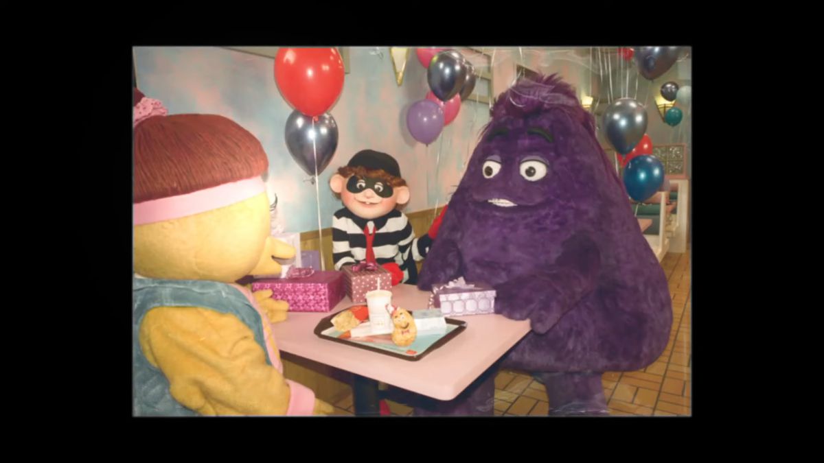 صورة قديمة لـGrimace وهامبرغر وBirdie وEarly Bird يجلسون حول طاولة ويأكلون ماكدونالدز.