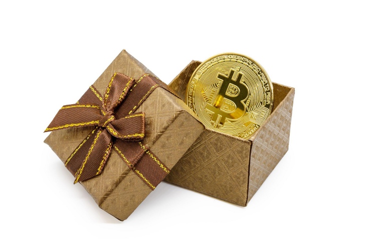 symbole bitcoin sur une pièce d'or dans une boîte cadeau en or