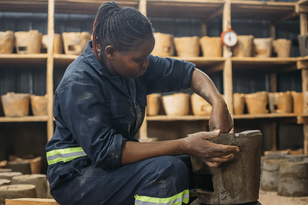 Tầm quan trọng của việc bù đắp carbon trong việc đạt được mức 6 ròng_Một phụ nữ địa phương làm việc trong một nhà máy sản xuất bếp nấu_visual XNUMX