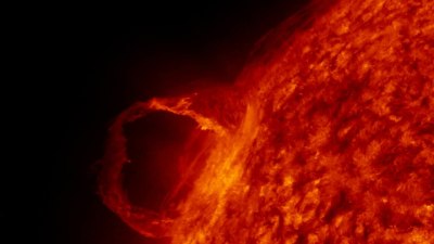 Het oppervlak van de zon met een plasmadraad in gevlekt oranje, met daarachter het zwart van de ruimte.