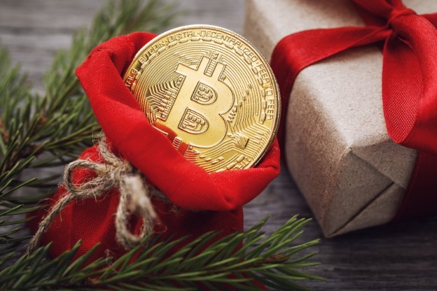 gouden munt met bitcoin-symbool in een rood cadeauzakje