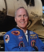 L'astronauta Tom Jones in piedi davanti allo Space Shuttle Atlantis